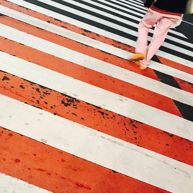 Photo la partie inférieure d'une femme marchant sur le passage des zèbres