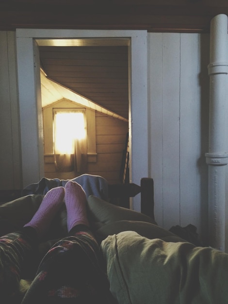 Photo la partie inférieure d'une femme portant des chaussettes sur le lit