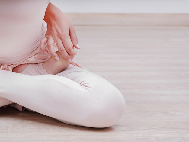 La partie inférieure de la femme pratiquant le yoga à la maison