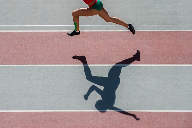 La partie inférieure d'une femme qui court sur la piste