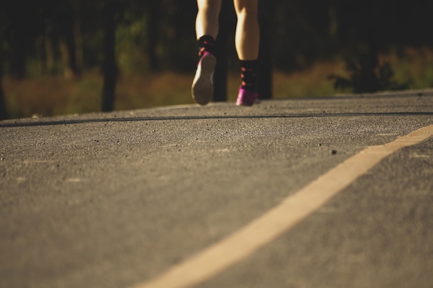 La partie inférieure d'une femme qui court sur la route