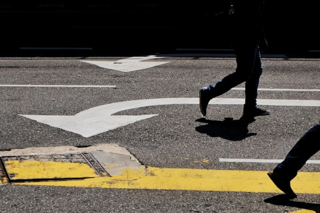 La partie inférieure d'une femme qui marche sur la route