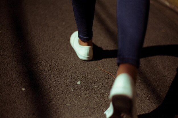 Photo la partie inférieure d'une femme qui marche sur la route