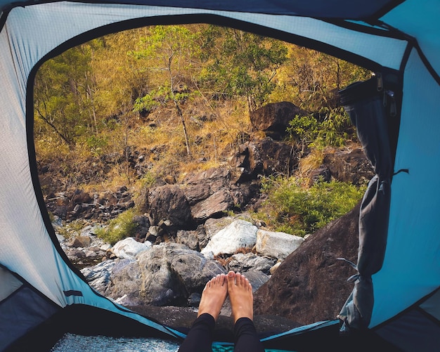 Photo la partie inférieure d'une femme se détendant dans une tente dans la forêt