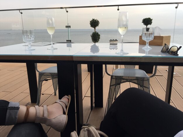 La partie inférieure des femmes assises à table avec du champagne.