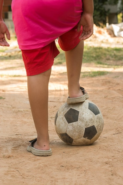 Photo la partie inférieure d'un garçon jouant avec un ballon de football