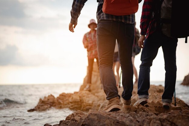 La partie inférieure des gens qui marchent sur la plage