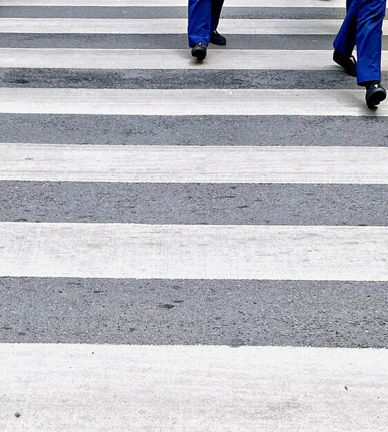 Photo la partie inférieure des gens qui traversent la route