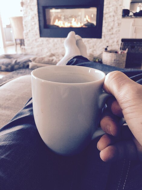 Photo une partie inférieure de l'homme buvant du café à la maison