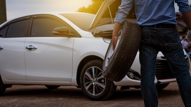 La partie inférieure de l'homme debout près de la voiture sur la route