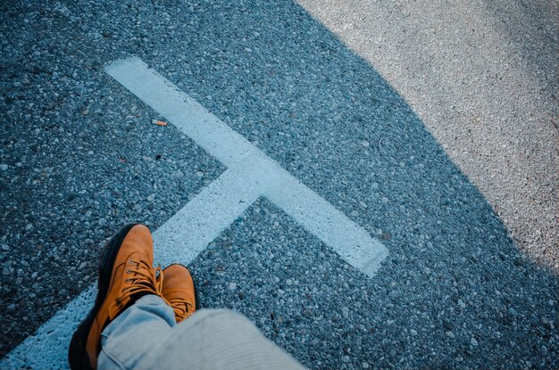 La partie inférieure de l'homme debout sur la route