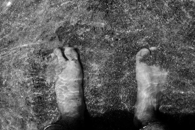 Photo la partie inférieure de l'homme debout sur le sable de la mer