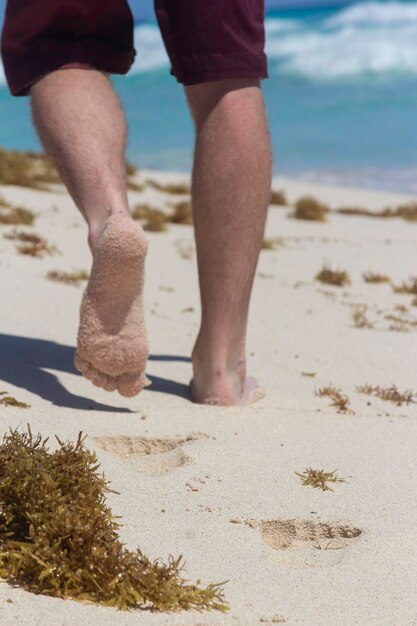 Photo la partie inférieure de l'homme debout sur le sable