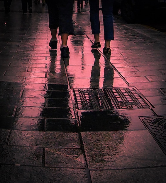 Photo une partie inférieure de l'homme debout sur le trottoir mouillé pendant la saison des pluies