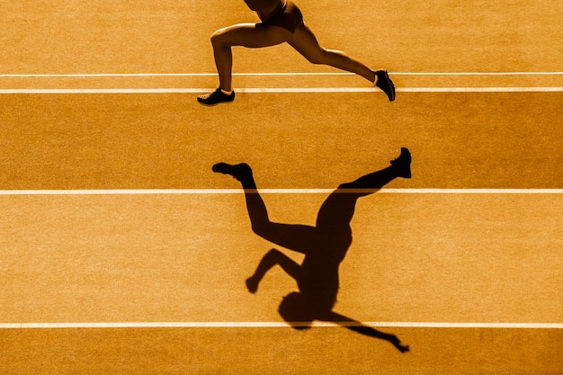 La partie inférieure de l'homme qui court sur la piste