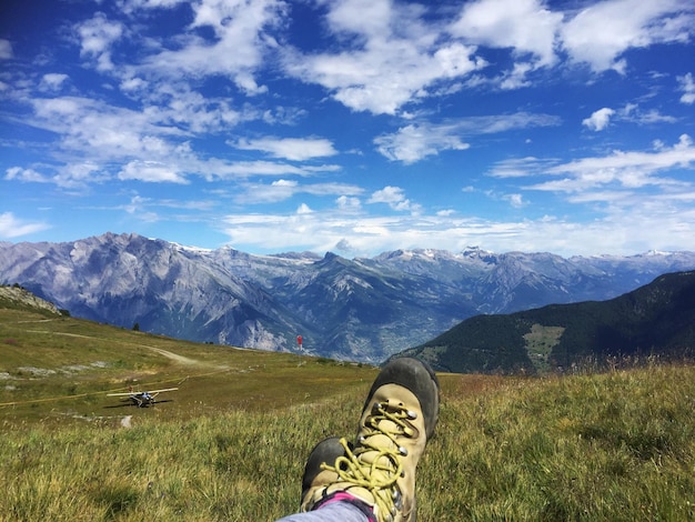 Une partie inférieure de l'homme reposant sur la montagne contre le ciel
