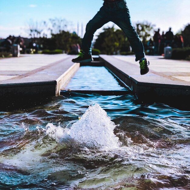 Photo la partie inférieure de l'homme sautant sur la fontaine