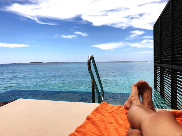 Photo la partie inférieure de l'homme se détend au bord de la mer