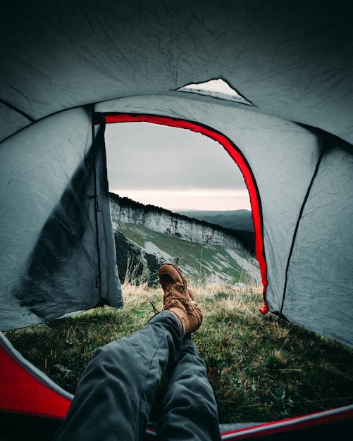 Photo la partie inférieure de l'homme se détend dans une tente sur la montagne