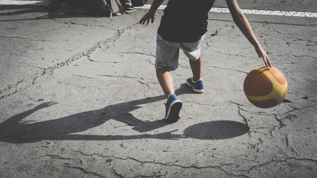 Photo une partie inférieure d'hommes jouant au ballon dans la rue