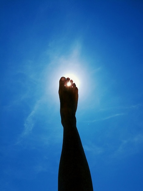 Photo la partie inférieure de la jambe contre le soleil dans le ciel bleu