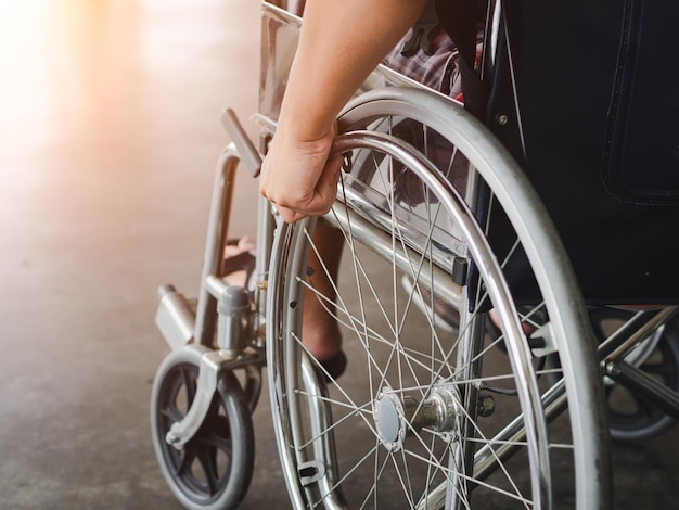 La partie inférieure d'une personne assise dans un fauteuil roulant en ville