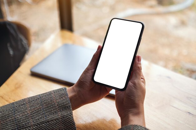 Photo la partie inférieure de la personne utilisant le téléphone portable sur la table