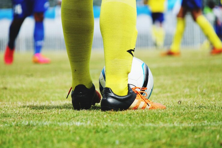 Photo la partie inférieure d'un sportif jouant au football sur l'herbe