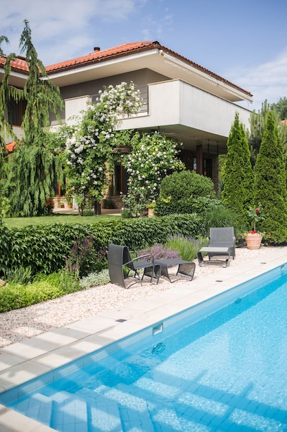 Une partie de la maison contre le ciel donnant sur le jardin et le territoire bien entretenu