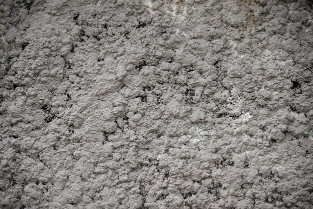 Partie d'un mur de sable de ciment peint en gris texturé