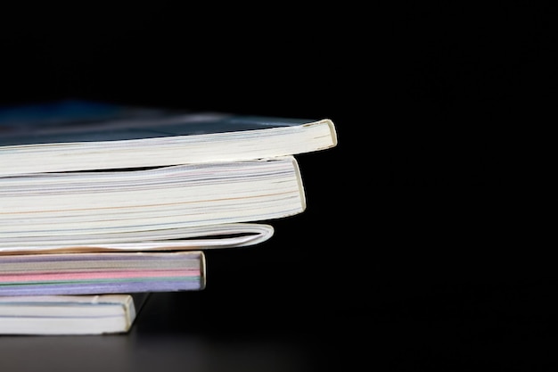 Une partie d'une pile de magazines sur fond sombre