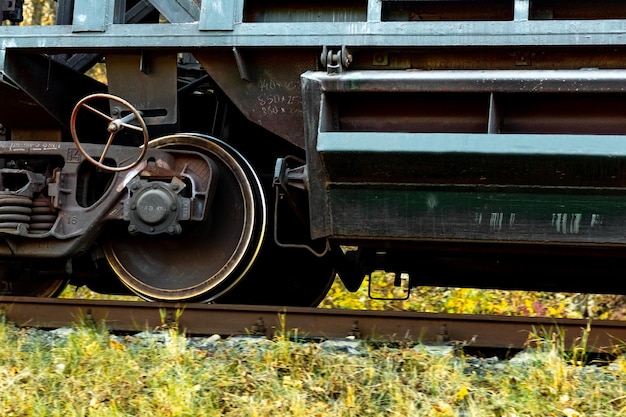 Partie d'un wagon de marchandises avec des roues massives pendant le mouvement du train sur la voie