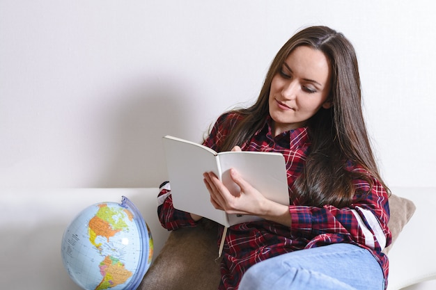 Partir à L'aventure. Jolie Femme Rêvant De Voyager à Travers Le Monde, Prenant Des Notes Dans Un Journal Intime Avec Les Pays De Voyage. Bonne Brunette Mignonne Prépare Pour Le Voyage