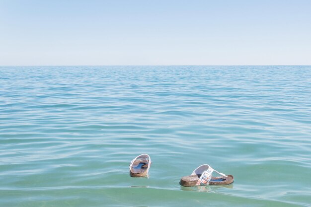 Partis dans l'océan les pantoufles pour femmes de la mer Chaussures perdues en vacances Le concept de la fin des vacances se séparant de la mer