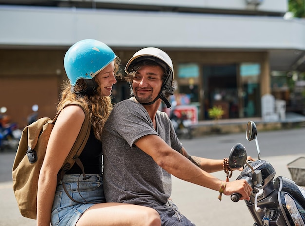 Partons à l'aventure Photo de deux routards heureux conduisant une moto à travers une ville étrangère