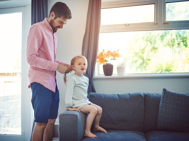 Pas un cheveu déplacé quand papa le fait Photo d'un père qui brosse les cheveux de sa fille à la maison