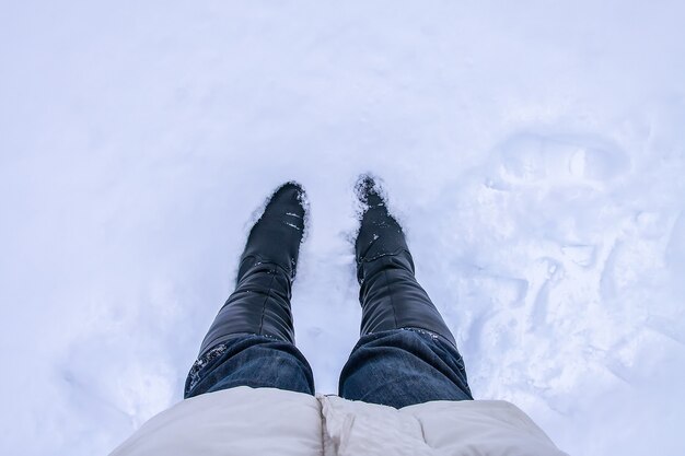 Un pas dans une neige profonde. Jambes en jean bleu dans une dérive.