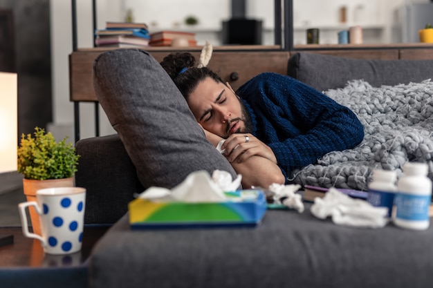 Pas d'Energie. Homme fatigué malheureux s'endormir sur le canapé tout en étant très fatigué