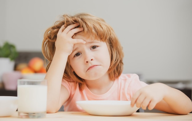 Pas faim L'enfant refuse de manger L'enfant n'a pas d'appétit Un petit enfant bouleversé refuse de manger des céréales biologiques avec du lait Nutrition de l'enfant