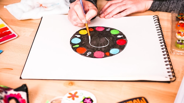 Pas à pas. Baker esquissant le dessin d'un gâteau à l'aquarelle pour les vacances de Dia de los Muertos.