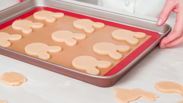 Pas à pas. Biscuits au sucre de Pâques non cuits disposés pour la cuisson sur une plaque à pâtisserie.