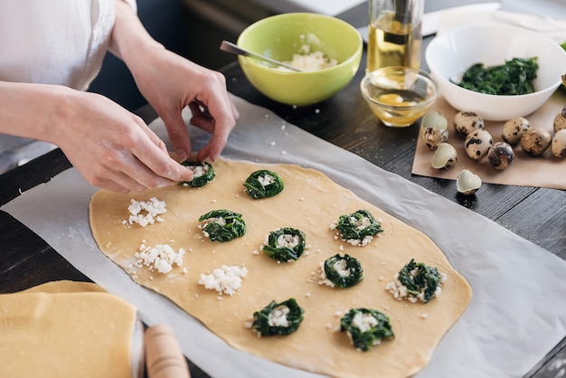 Pas à pas le chef prépare des raviolis avec de la ricotta, des jaunes d'œufs de caille et des épinards aux épices. Le chef prépare la garniture sur la pâte