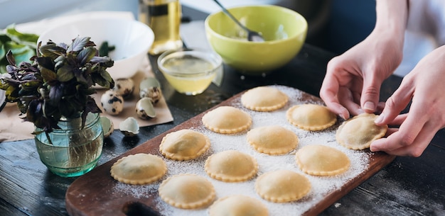 Pas à pas le chef prépare des raviolis avec de la ricotta, des jaunes d'œufs de caille et des épinards aux épices. Le chef se prépare à cuisiner des raviolis