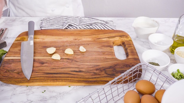 Pas à pas. Écraser l'ail pour l'ajouter à une recette de gâteau aux courgettes.