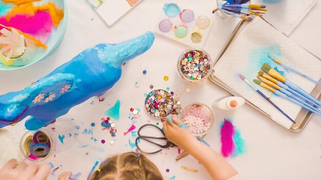 Pas à pas. décoration de licorne en papier mâché peint avec des fleurs et des bijoux en papier.