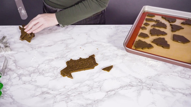 Pas à pas. Découper des formes avec un emporte-pièce pour biscuits de Noël dans de la pâte à biscuits au pain d'épice.