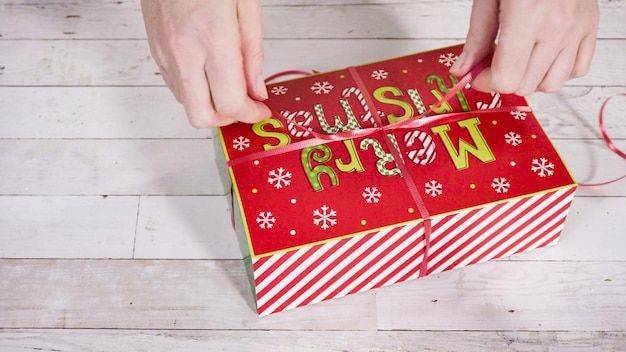 Pas à pas. Emballage de fudge et de biscuits faits maison dans une boîte-cadeau de Noël.