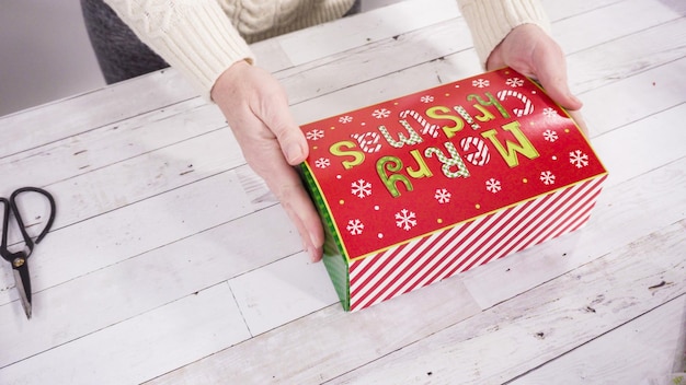 Pas à pas. Emballage de fudge et de biscuits faits maison dans une boîte-cadeau de Noël.