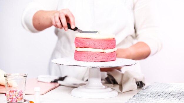 Pas à pas. Empiler des couches de gâteau d'anniversaire rose.