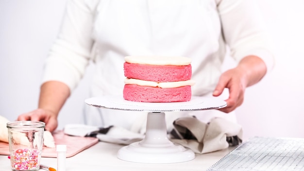 Pas à pas. Empiler des couches de gâteau d'anniversaire rose.